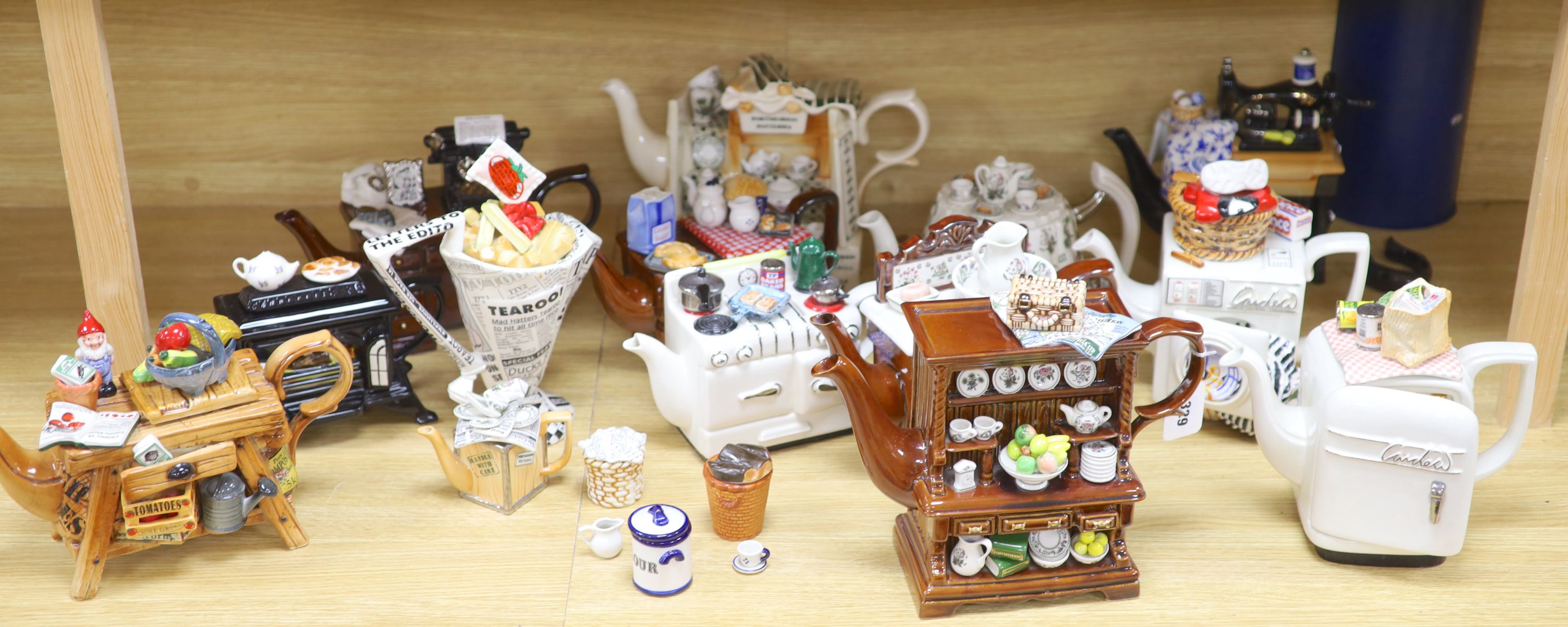 A collection of thirteen Portmeirion and Cardew novelty teapots, including dresser, sewing machine and kitchen range examples